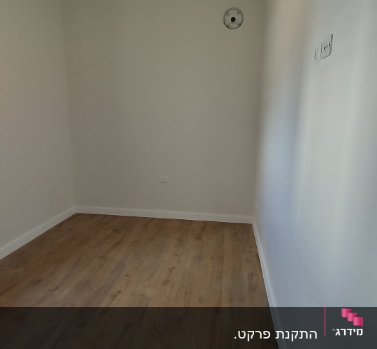 חדר עם רצפת פרקט וחלון פתוח